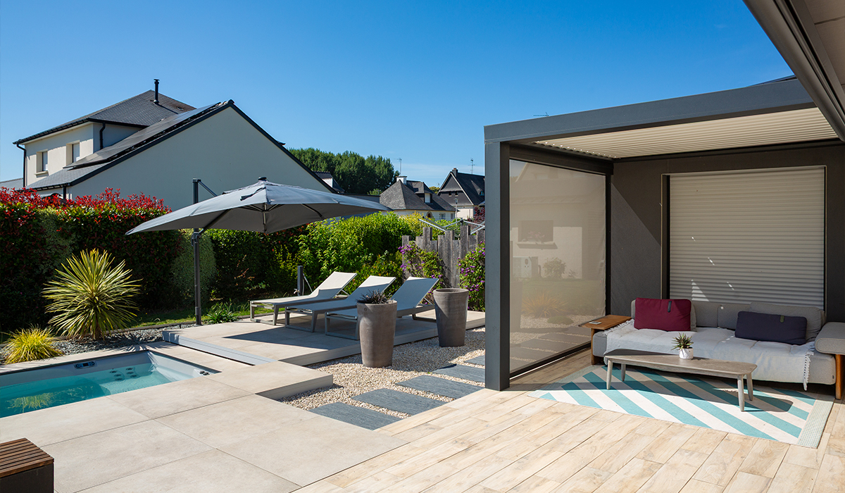 une piscine avec un salon de jardin et un pool house