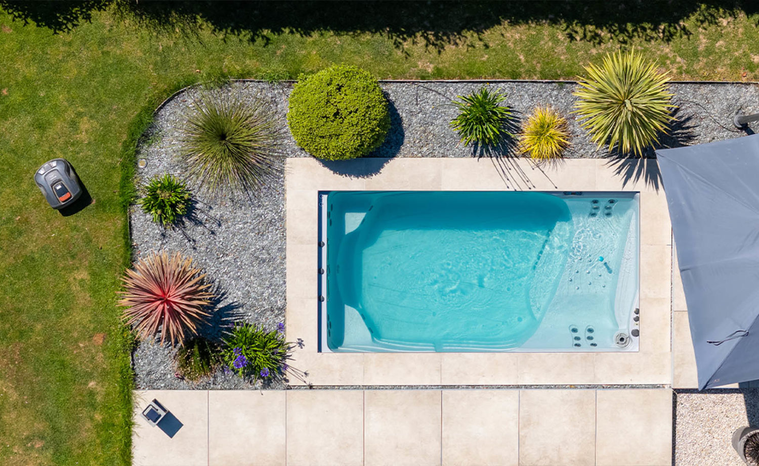 aménagement paysager autour d'une piscine enterrée par Désiles Piscine en Ille-et-Vilaine avec haie et margelles